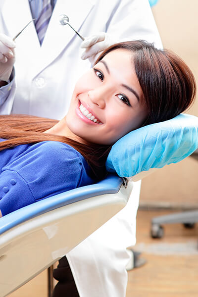 A young woman lying in the dentist's chair while smiling