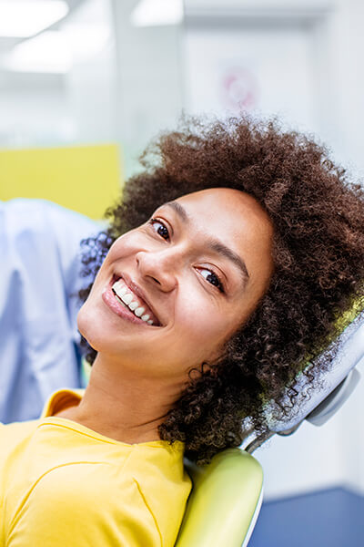 Your trusted dentist for dental emergencies A woman in the dentist's chair smiling